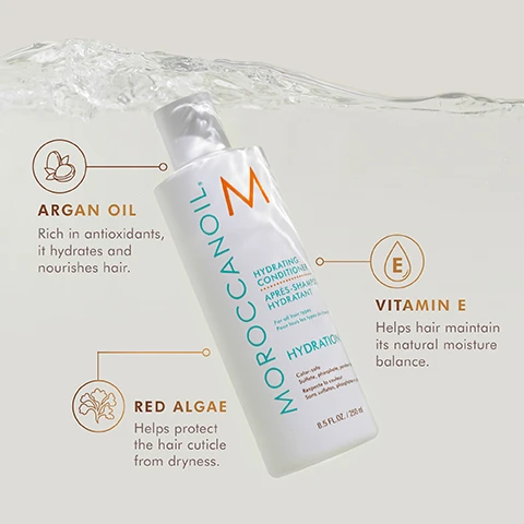 Image 3 - A bottle of Moroccanoil Hydrating Conditioner is submerged in water, with text labels indicating key ingredients: Argan Oil, Vitamin E, and Red Algae, along with their benefits for hair.
Image 4 - Before and after image comparison showing a woman with curly hair on the left looking less defined and on the right looking vibrant and well-defined, wearing a gray tank top with the text above reading BEFORE on the left and AFTER on the right, and additional text below stating results achieved using Hydrating Shampoo and Conditioner, All in One Leave-in Conditioner, and Intense Hydrating Mask.
Image 5 - Image shows two bottles of Moroccanoil Hydrating Shampoo and Conditioner placed on a light-colored surface, with text indicating they are sulfate, phosphate, and paraben-free, along with descriptions of moisture-balancing formulas and their ability to increase manageability and shine.
