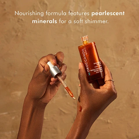 Image 2 - Two hands hold a dropper above a small bottle of Moroccanoil Shimmering Body Oil against a neutral background, and visible text reads Nourishing formula features pearlescent minerals for a soft shimmer.
Image 4 - A collection of four Moroccanoil body oils is displayed on a light background, labeled with the titles Night Body Serum, Shimmering Body Oil, Dry Body Oil, and Pure Argan Oil.