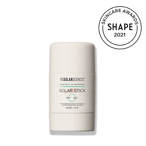 Image 2-dermstore-en_US - A white cylindrical MD Solar Sciences Solar Stick SPF 40 sunscreen is shown next to a Skincare Awards Shape 2021 badge. The stick is labeled MDSOLARSCIENCES, PROTECT & NOURISH, SOLAR STICK, SPF 40, TINTED BROAD SPECTRUM SPF 40 WATER RESISTANT (80 MIN), 0.6 OZ / 17 G, and the award badge reads SKINCARE AWARDS SHAPE 2021. Image 3-dermstore-en_US - Various natural ingredients are displayed, including a pile of brown powder, a bowl of white shea butter with a shea nut, an orange slice, yellow vitamin capsules, and white powder, with accompanying text that states: SCIENCE-BASED INGREDIENTS, SHEA BUTTER Softens & smooths skin, VITAMIN C + E Stimulates collagen production to firm skin, MICRONIZED ZINC OXIDE 100% broad spectrum mineral protection. Image 4-dermstore-en_US - A white Mosolarsciences Solar Stick sunscreen is shown partially open with its cap next to it, revealing the tinted stick, alongside the text POCKET-SIZED PROTECTION, Non-nano mineral SPF 40 protection, Convenient, portable, & easy to blend, Safe for sensitive skin, Water resistant for up to 80 minutes, and on the product, MOSOLARSCIENCES PROTECT & NOURISH, SOLAR STICK SPF 40, TINTED BROAD SPECTRUM SPF 40 WATER RESISTANT (80 MIN) 0.6 OZ / 17 G. Image 5-dermstore-en_US - A smiling persons face has a hand holding a stick product to their cheek, with text on the product reading SOLARSCIENCES PROTECT & NOURISH BAR STICK, and accompanying text on the right reads SWIPE AND GLOW, Universally flattering tint with matte finish, Oil-free and non-comedogenic, Lightweight formula glides on silky smooth, Wear as primer or on its own. Image 6-dermstore-en_US - A white MDSOLARSCIENCES Solar Stick SPF 40 sunscreen stands upright on a pale background, with scattered light brown makeup powder in the top left corner, displaying the text DERMATOLOGIST DEVELOPED. BEAUTY-EXPERT APPROVED. THE BEST SUNSCREEN STICKS FOR EASY, BREEZY SUN PROTECTION ON THE GO VOGUE THE 2021 SHAPE BEAUTY AWARDS: BEST SUNSCREEN STICK SHAPE, and the stick label reads MDSOLARSCIENCES PROTECT & NOURISH SOLAR STICK SPF 40 TINTED BROAD SPECTRUM SPF 40 WATER RESISTANT (80 MIN) 0.6 OZ / 17 G. Image 7-dermstore-en_US - The image shows four MDSOLARSCIENCES skincare products on a neutral background, featuring the headline EXPLORE THE COLLECTION and the tagline Scientifically formulated to elevate your everyday skincare routine, with the individual products being a Quick Dry Body Spray SPF 40 (6 FL OZ / 177 ML) offering Sheer Protection; a Mineral Moisture Defense SPF 50 (3.4 FL OZ / 100 ML), a Hydrating Mineral Sunscreen Enriched with Ceramides; a Solar Stick SPF 40 (0.5 OZ / 15 G); and a Wash Away One Step Cleanser (1.7 FL OZ / 50 ML) for Day & Night which gently exfoliates, purifies, cleans pores, and removes impurities, makeup, and sunscreen; all three sunscreens are labeled PROTECT & NOURISH, Broad Spectrum, Water Resistant (80 Min), and DERMATOLOGIST DEVELOPED; the cleanser is labeled CLEANSE & NOURISH and is also DERMATOLOGIST DEVELOPED. Image 8-dermstore-en_US - A smiling blonde woman in a black top is shown with a red cosmetic smear in the top left corner, and text that reads: MDSOLARSCIENCES, DERMATOLOGIST - DEVELOPED • SPF + SKINCARE, SCIENCE ISNT OUR SECRET. ITS OUR STANDARD. At the heart of our brand is a commitment to true skin wellness, powered by science, elevated by luxury, and grounded in clean, feel-good formulas. RENEE PLATO, CEO.