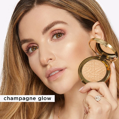 Image 1 - A woman with long, wavy hair holds a compact highlighter in one hand and looks directly at the camera, showcasing her makeup, with the text champagne glow visible to the left.
Image 2 - Two round compacts of highlighter are shown; the left compact is gold and labeled Champagne Glow, while the right compact is rose gold and labeled Rose Gold Glow, with their shades displayed as powder swatches below each compact.
Image 3 - A woman with braided hair holds a compact of makeup to her cheek while showcasing a radiant glow, with the visible text reading rose gold glow.
Image 4 - Two open compacts of highlighter sit on a light background, showcasing the products’ mirrored interiors; the left compact features circular highlighter with a chevron pattern, while the right compact contains a similar design, with visible text reading Microfine 3D Pearls reflect light adding depth & dimension, while diffusing imperfections and Buildable glow that doesnt look glittery.
Image 5 - A woman with long dark hair smiles while holding a compact with a blush shade, showcasing the rose gold glow, with visible text reading rose gold glow.