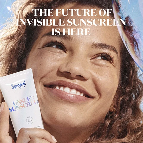 Image 1 - A smiling woman with curly hair holds a tube of sunscreen with the text Supergoop! Unseen Sunscreen SPF 50 visible on the tube, and the words THE FUTURE OF INVISIBLE SUNSCREEN IS HERE are displayed above her.
Image 2 - Close-up of a womans face with her eyes closed, showing a translucent gel on her cheek with text stating IMPROVES SKIN CLARITY and ALL-DAY MAKEUP WEAR, along with descriptions of non-acnegenic formula and clinical testing results.
Image 3 - Image of a sunscreen tube with text highlighting key ingredients including chamomile-derived bisabolol, licorice root, meadowfoam seed oil, and broad spectrum SPF 50, recommending it for helping to soothe skin and prevent visible aging signs.
Image 4 - A tube of Supergoop! Unseen Sunscreen with a colorful label displaying the product name and SPF 50, set against a blue background, with text highlighting features like higher protection, lighter weight, clearer formula, and stronger benefits.