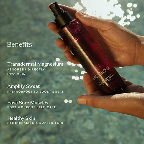 A persons hands hold a dark red spray bottle labeled Higherdose Transdermal Magnesium Spray 5 FL OZ / 150 ML, against a sparkling blue water background, with text listing Benefits: Transdermal Magnesium absorbs directly into skin, Amplify Sweat pre-workout to boost sweat, Ease Sore Muscles post-workout self-care, and Healthy Skin remineralize & soften skin.