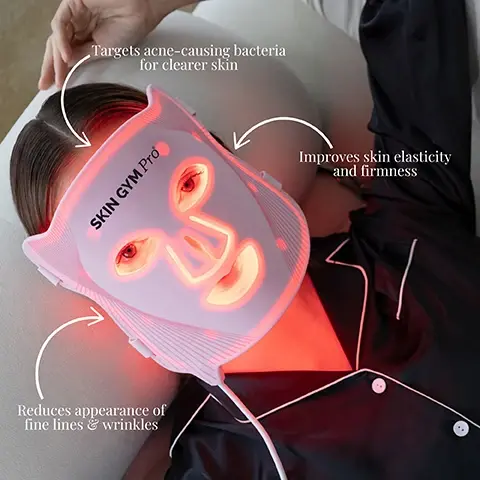 Image 1 - A woman wearing a facial LED mask with the text SKIN GYM Pro visible, highlights around the mask indicate its benefits: targets acne-causing bacteria for clearer skin, improves skin elasticity and firmness, and reduces appearance of fine lines and wrinkles.
Image 2 - A pink facial mask with multiple small lights is shown, accompanied by text explaining the benefits of red light at 630nm for reducing fine lines, blue light at 465nm for targeting acne, and near-infrared light at 830nm for deeper skin penetration.