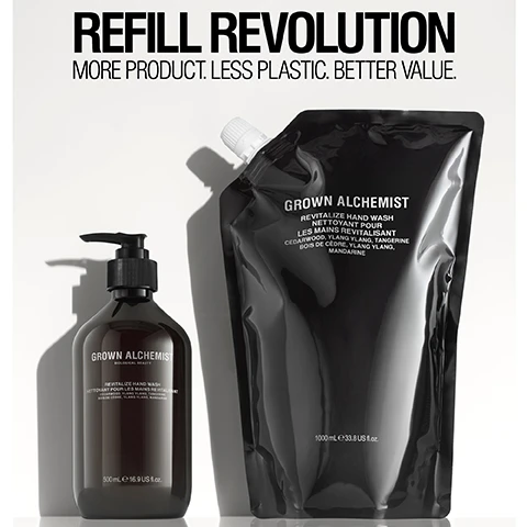 Image 1 - A black pump bottle and a black pouch of hand wash are displayed side by side, with large text above reading REFLILL REVOLUTION and smaller text below stating MORE PRODUCT. LESS PLASTIC. BETTER VALUE. The label on the pump bottle says GROWN ALCHEMIST REVITALIZE HAND WASH and the pouch states GROWN ALCHEMIST REVITALIZE HAND WASH in both English and French.
Image 2 - An overhead view of a clear glass petri dish containing a transparent, bubbly gel, with labels pointing to the gel describing natural surfactants that create luxurious low foam lather without stripping and an aromatic essential oil blend of cedarwood, ylang ylang, and tangerine that leaves skin subtly scented.