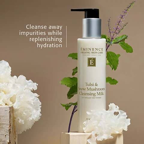 Image 1 - A cream-colored pump bottle for skincare is displayed on a warm brown background with green plant stems and white frilly snow mushrooms arranged on wooden blocks, alongside text that reads Cleanse away impurities while replenishing hydration; the bottle itself is labeled ÉMINENCE ORGANIC SKIN CARE HUNGARY • SINCE 1958, an É logo, Tulsi & Snow Mushroom Cleansing Milk, Lait nettoyant Tulsi-Trémelle, and All Ski. Image 2 - A close-up of a creamy white cleansing milk on a beige background, with an É logo in a brown square in the bottom right, accompanied by the text: TULSI & SNOW MUSHROOM CLEANSING MILK Formulated with adaptogenic tulsi, reishi and snow mushroom to calm visible signs of stress. Image 3 - An image features a close-up background of light-colored mushroom gills, overlaid by a central brown circle with the text Destress Your Skin, followed by Relax and replenish with the results-driven Pure Forest Collection. Adaptogenic ingredients are harnessed to enhance the mind-body connection, transform your complexion and calm the visible effects of stress, and a green square logo with the letter É is in the top right corner. Image 4 - An image shows three Eminence Organic Skin Care products on a white, textured background resembling snow fungus, with the text Connect with Nature. Reconnect with Yourself. WITH THE PURE FOREST COLLECTION. The products include a Tulsi & Snow Mushroom Cleansing Milk Lait nettoyant Tulsi-Trémelle pump bottle, a Shiitake & Ashwagandha Bi-Phase Mist Brume biphasée Shiitake-Ashwagandha WITH BLUE LIGHT COMPLEX All Skin Types spray bottle, and an Ashwagandha Ultra-Rich Restorative Cream Crème restauratrice ultrariche à l’ashwagandha 150 ml / 5 fl oz jar. Image 5 - Three Éminence Organic Skin Care products, a tall bottle of Essence, a small jar of Eye Cream, and a wider jar of Masque, are displayed on a reflective surface with white snow mushroom details in the background, and the visible text reads: Check out more Pure Forest favorites from Éminence Organics. Éminence Organic Skin Care Hungary Since 1958 É Birch Water Purifying Essence Essence d’eau de bouleau purifiante All Skin Types 120 ml / 4 fl oz. Éminence Organic Skin Care Snow Mushroom Moisture Cloud Eye Cream 15 ml / 0.5 fl oz. Éminence Organic Skin Care Snow Mushroom & Reishi Masque 60 ml / 2 fl oz.