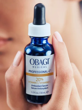 A hand holding a bottle of Obagi Medical Professional-C Serum, a high-potency Vitamin C antioxidant treatment for brightening and skin rejuvenation